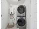 Compact laundry room featuring a stacked washer and dryer and a modern water heater system at 7812 W 43Rd Pl, Wheat Ridge, CO 80033