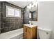 Bathroom features modern vanity, decorative mirror, shower, and tiled wall at 3940 S Hazel Ct, Englewood, CO 80110
