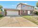 Brick and gray two-story house with attached garage and landscaped yard at 10825 Brewer Dr, Northglenn, CO 80234