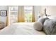 Bedroom with natural light from two windows with garden view and decorative pillows on bed at 6495 E Happy Canyon Rd # 114, Denver, CO 80237