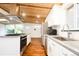 Well-lit kitchen showcases modern appliances, white cabinets, hardwood floors, and skylight at 7695 Quitman St, Westminster, CO 80030