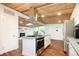 Bright kitchen boasts stainless steel appliances, island cooktop, and stylish wood ceiling at 7695 Quitman St, Westminster, CO 80030