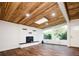 Sun-filled living room features a modern brick fireplace, stylish wood floors, and a striking wood ceiling with a skylight at 7695 Quitman St, Westminster, CO 80030