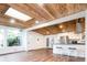Bright open-concept living space with wood floors and unique wooden ceilings that flows seamlessly into the modern kitchen at 7695 Quitman St, Westminster, CO 80030