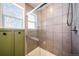Updated bathroom featuring a glass shower, neutral tiling, and decorative window at 19120 E 54Th Pl, Denver, CO 80249