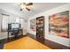 Home office with dark wood floors, vibrant artwork, desk, chair, and large window at 19120 E 54Th Pl, Denver, CO 80249
