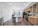 Kitchen boasts a large island with barstool seating, wood cabinets, and a view to the backyard at 19120 E 54Th Pl, Denver, CO 80249