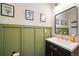 Powder room with green wainscoting, framed mirror, and updated vanity at 19120 E 54Th Pl, Denver, CO 80249