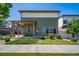 The side exterior features green siding, a covered patio with seating, and manicured bushes at 19120 E 54Th Pl, Denver, CO 80249