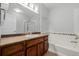 Bathroom featuring a wooden vanity, bath tub with tile backsplash, and glass enclosed shower at 13456 Via Varra # 401, Broomfield, CO 80020