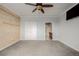 Spacious bedroom featuring carpet floors, wood accent wall, a closet, and an ensuite bathroom, offering comfort and privacy at 13456 Via Varra # 401, Broomfield, CO 80020