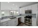 Modern kitchen boasting white cabinets, stainless appliances, stone countertops, and a stylish tiled backsplash at 13456 Via Varra # 401, Broomfield, CO 80020