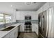 Stylish kitchen with stainless steel appliances, quartz countertops, and backsplash; ample storage space for the home chef at 13456 Via Varra # 401, Broomfield, CO 80020