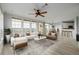 Bright living room with a ceiling fan, expansive windows, and a stylish rug adjacent to the open concept kitchen at 13456 Via Varra # 401, Broomfield, CO 80020