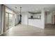 Bright living room with wood floors, kitchen view and sliding glass door for balcony access at 13456 Via Varra # 401, Broomfield, CO 80020