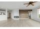 Bright living room with wood floors, accent wall, fireplace, ceiling fan, and kitchen view at 13456 Via Varra # 401, Broomfield, CO 80020