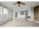 Bright living room with wood floors, accent wall, fireplace, ceiling fan, and open to kitchen at 13456 Via Varra # 401, Broomfield, CO 80020