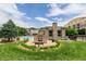 The community pool area has a stone fireplace, lounge chairs, and lush landscaping at 13456 Via Varra # 401, Broomfield, CO 80020