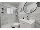 Updated bathroom with marble tile and modern vanity at 9303 W 66Th Pl, Arvada, CO 80004