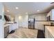 Spacious kitchen with stainless steel fridge, white cabinets, and wood look flooring at 11120 Josephine Way, Northglenn, CO 80233