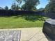 Large backyard with lush green grass, wooden fence, and a patio area with a grill at 12528 Ash St, Thornton, CO 80241