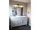 Bright bathroom featuring a double sink vanity, modern lighting, and a walk-in shower at 12528 Ash St, Thornton, CO 80241