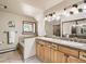 Bright bathroom with a bathtub, dual sink vanity, and a window at 2012 Tournament Ct, Evergreen, CO 80439