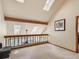 Lofted room with neutral carpet and paint, skylights, and wood railings at 2012 Tournament Ct, Evergreen, CO 80439