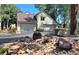 Charming home with a two-car garage, landscaped front yard and classic stone bench at 2012 Tournament Ct, Evergreen, CO 80439