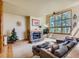 Bright living room with stone fireplace and large window offering natural light at 2012 Tournament Ct, Evergreen, CO 80439