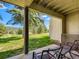 Covered patio area with seating overlooking a well-maintained lawn and picturesque landscape at 2012 Tournament Ct, Evergreen, CO 80439