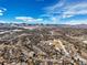 Vast aerial view captures a sprawling residential area nestled against snow-capped mountains under a blue, cloudy sky at 7862 W Euclid Pl, Littleton, CO 80123