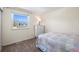 Bright bedroom features a patterned quilt, large window, and dresser, providing a relaxing space at 7862 W Euclid Pl, Littleton, CO 80123