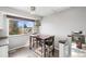 Sunlit breakfast nook features a dark wood table set, large window, and stylish light fixture at 7862 W Euclid Pl, Littleton, CO 80123