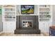 Close up view of a modern fireplace with built-in shelving on either side at 7862 W Euclid Pl, Littleton, CO 80123