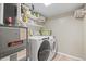 Well-equipped laundry room with modern washer and dryer, ample shelving, and utility connections at 7862 W Euclid Pl, Littleton, CO 80123