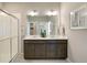 Elegant bathroom featuring double sinks, a framed mirror, and a walk-in shower at 4621 Cattle Cross Trl, Castle Rock, CO 80104