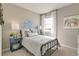 Cozy bedroom with decorative wall art, a stylish bed, bedside tables, and a sunlit window at 4621 Cattle Cross Trl, Castle Rock, CO 80104