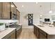 Bright kitchen features stainless steel appliances, white countertops, and wood-look flooring at 4621 Cattle Cross Trl, Castle Rock, CO 80104