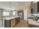 Well-lit kitchen featuring stainless steel appliances, a large island, and wood-style flooring at 4621 Cattle Cross Trl, Castle Rock, CO 80104