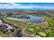 Expansive aerial view showcasing a lake, golf course, and residential area in a scenic community setting at 15333 Heritage Cir, Thornton, CO 80602