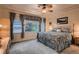 Comfortable bedroom with tray ceiling, ceiling fan and a view of the outdoors at 15333 Heritage Cir, Thornton, CO 80602