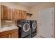 Laundry room with modern washer and dryer units and ample storage at 15333 Heritage Cir, Thornton, CO 80602