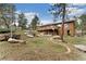 Expansive backyard with mature trees and a charming water feature flowing down to the lower yard at 11398 Ranch Elsie Rd, Golden, CO 80403