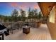 Spacious deck with seating, a fire pit, and beautiful views of the lush, green forest at 11398 Ranch Elsie Rd, Golden, CO 80403