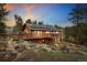 Charming cabin-style home with a large deck, solar panels, and a beautiful wooded surrounding at 11398 Ranch Elsie Rd, Golden, CO 80403