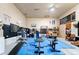 Bright home gym with lots of equipment, work bench, and sliding barn doors to the rest of the home at 11398 Ranch Elsie Rd, Golden, CO 80403