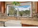 Close-up of kitchen with granite countertops, a farmhouse sink, and a beautiful view of the mountain scenery at 11398 Ranch Elsie Rd, Golden, CO 80403