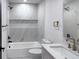 Modern bathroom with marble tile, updated fixtures, and a shower-tub combination at 1455 S Tennyson St, Denver, CO 80219