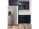 Kitchenette with stainless steel appliances and dark cabinetry with marble countertops at 1455 S Tennyson St, Denver, CO 80219